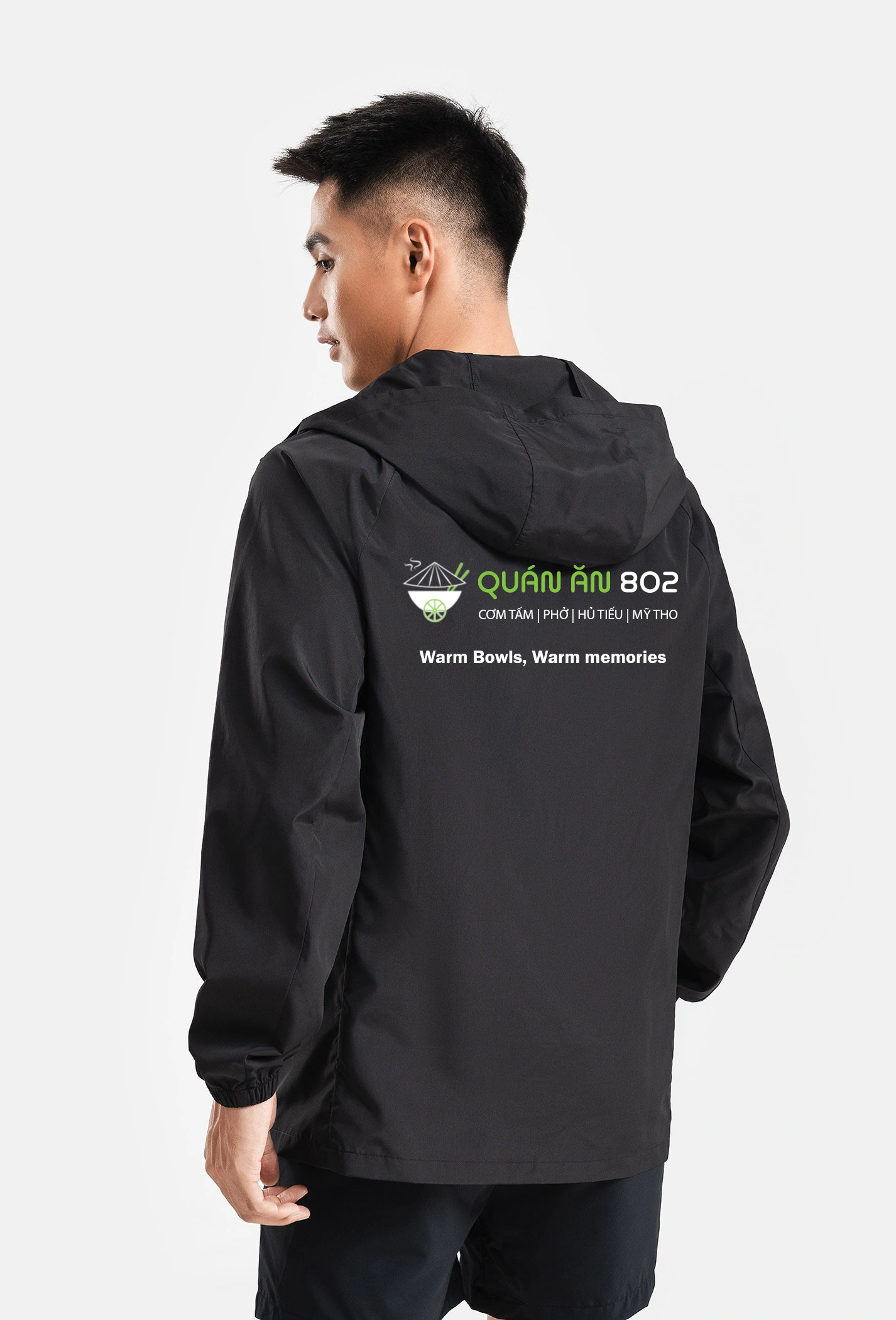 Staff uniform windbreaker jacket back print showing Quán Ăn 802 logo